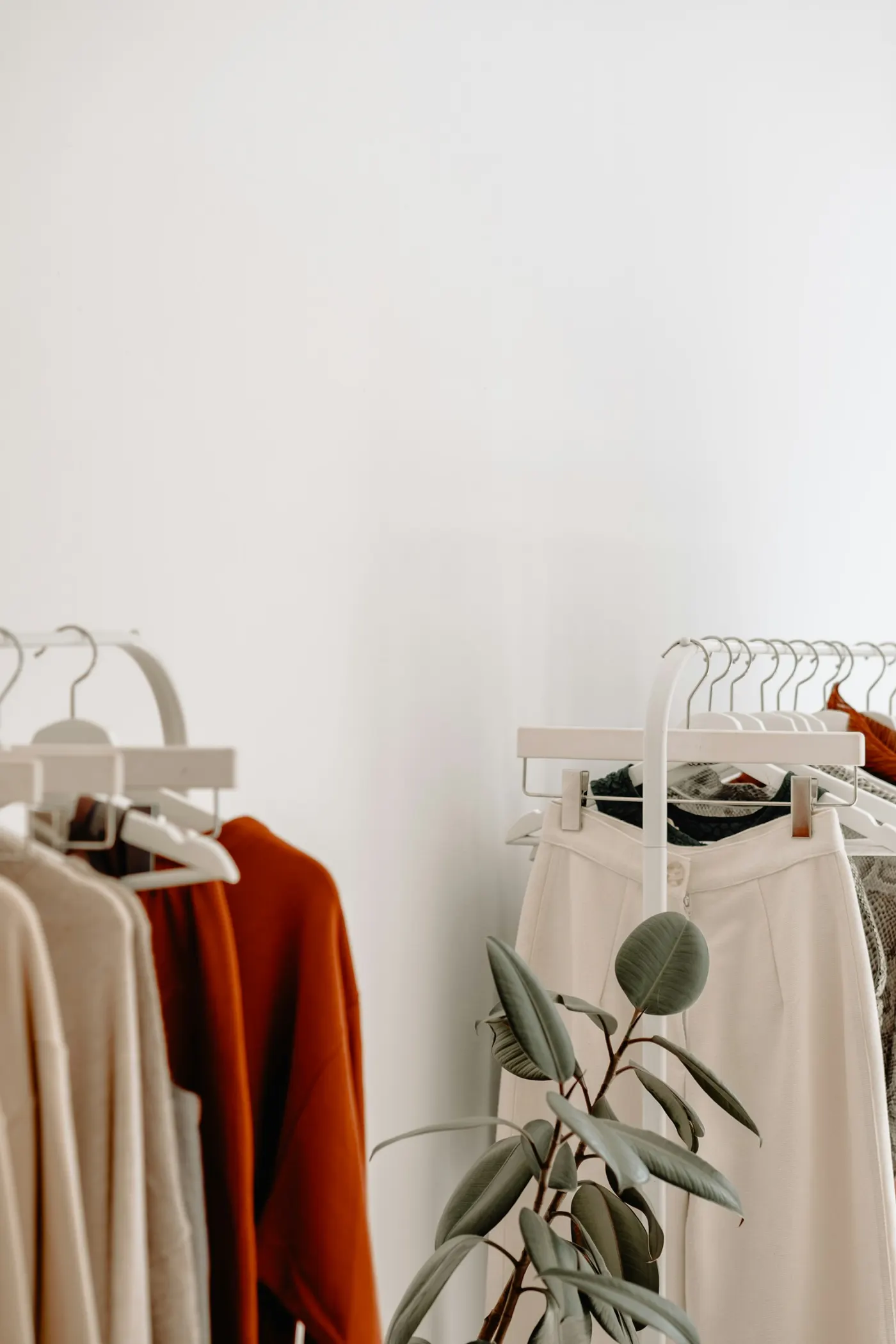 Neutral-toned clothing hanging on racks in a boutique showroom